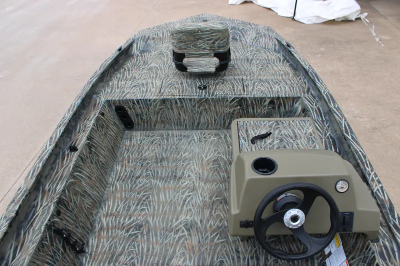 Slide: The Image of 2026 Tracker Grizzly 1754 SC boat interior with camouflage design and steering console. - 5