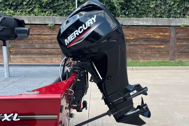 Slide: The Image of 2026 Tracker Bass Tracker Classic XL with Mercury outboard motor, parked outdoors. - 2