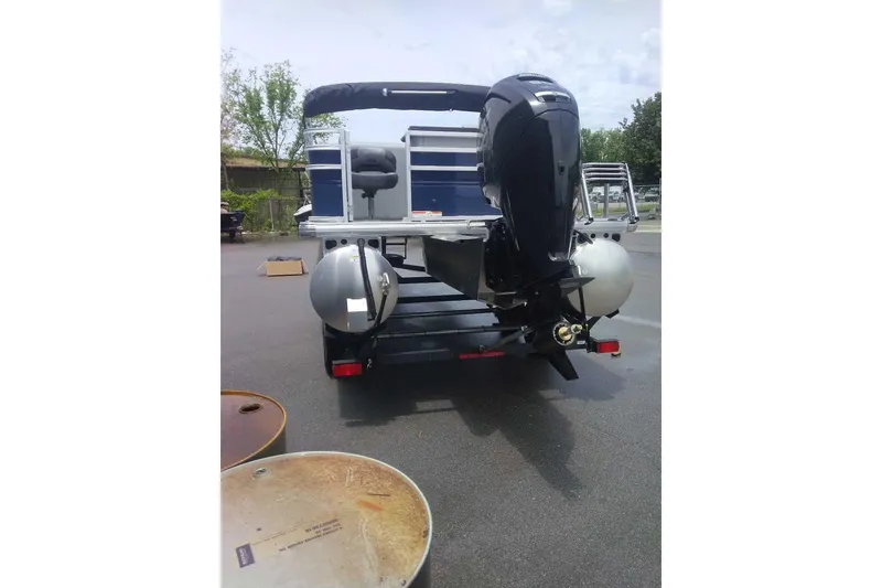 Slide: The Image of 2026 Sun Tracker SportFish 20 DLX pontoon boat with powerful outboard motor, parked outdoors. - 13