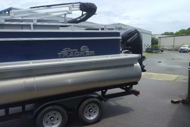 Slide: The Image of 2026 Sun Tracker SportFish 20 DLX pontoon boat on trailer, featuring Mercury outboard motor. - 4