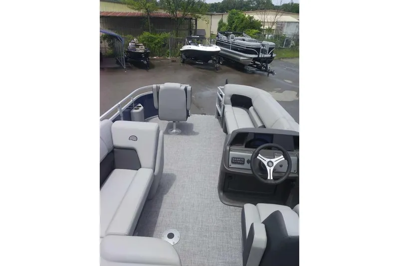 Slide: The Image of 2026 Sun Tracker SportFish 20 DLX pontoon boat interior with seating and steering console. - 5