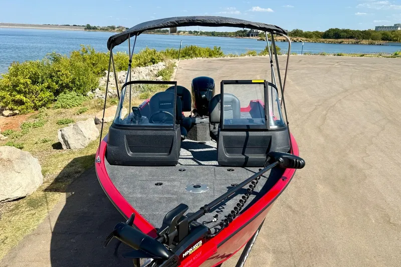 Slide: The Image of 2026 Tracker Pro Guide V-16 WT boat parked by a scenic lakeside. - 16