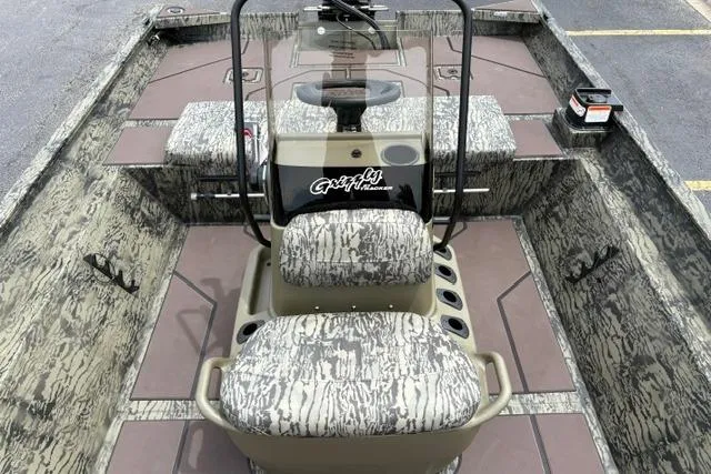 Slide: The Image of 2026 Tracker Grizzly 2072 CC boat interior with camouflage seating and console. - 16