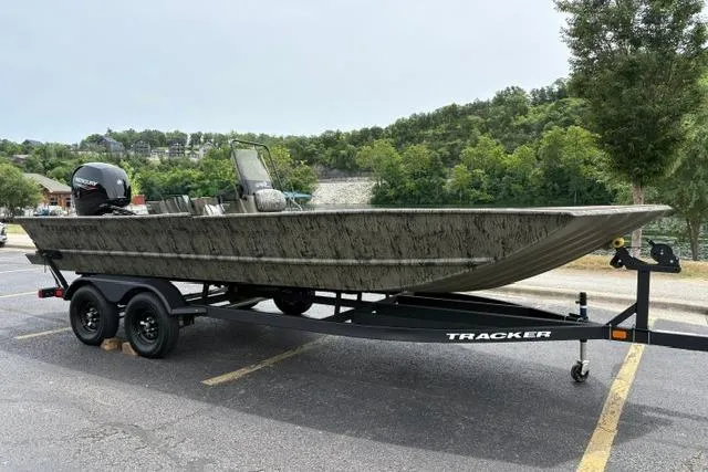 Slide: The Image of 2026 Tracker Grizzly 2072 CC boat on trailer in parking lot, surrounded by greenery. - 21