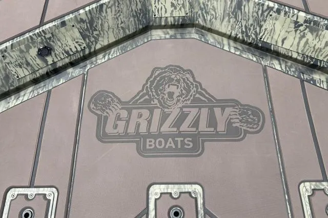 Slide: The Image of 2026 Tracker Grizzly 2072 CC boat deck with Grizzly Boats logo. - 22