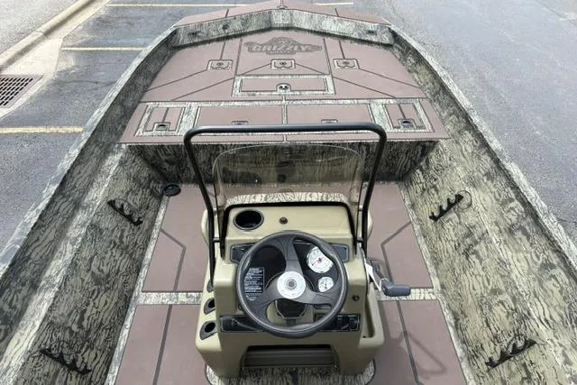 Slide: The Image of 2026 Tracker Grizzly 2072 CC boat interior with steering console and camouflage design. - 23
