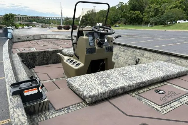 Slide: The Image of 2026 Tracker Grizzly 2072 CC boat interior with camouflage seating and steering console. - 24