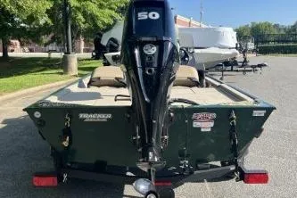 Slide: The Image of 2026 Tracker Bass Tracker Classic Limited boat with 50 HP motor, parked outdoors. - 5