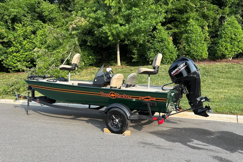 Slide: The Image of 2026 Tracker Bass Tracker Classic Limited boat with Mercury engine, parked outdoors. - 3