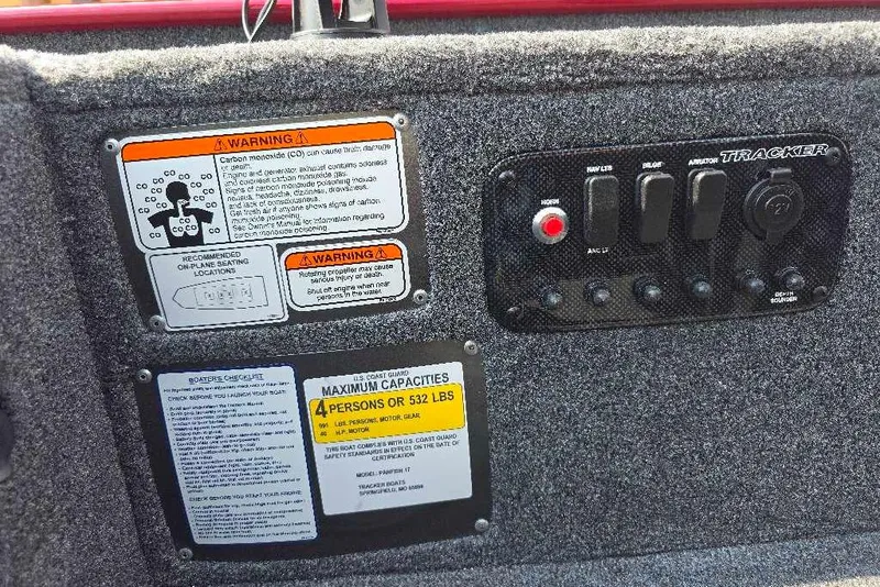 Slide: The Image of Control panel and warning labels on 2026 Tracker Panfish 17 boat interior. - 11