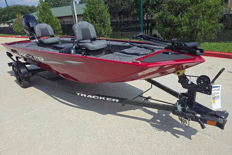 Slide: The Image of 2026 Tracker Panfish 17 boat in red, parked on a trailer, ready for fishing adventures. - 2
