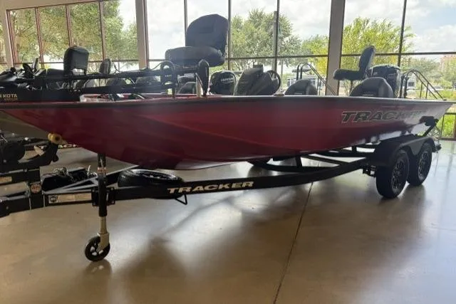 The Image of 2026 Tracker Pro Team 195 boat on trailer in showroom, featuring sleek red design. - 0
