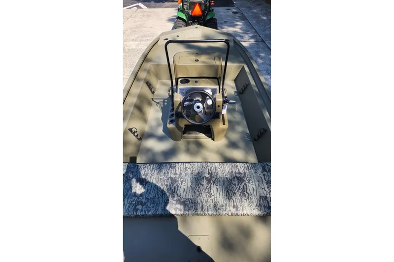 Slide: The Image of 2026 Tracker Grizzly 1860 CC boat interior with steering console and camouflage seating. - 4
