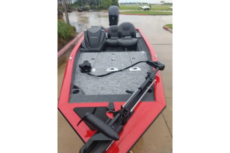 Slide: The Image of 2026 Tracker Pro Team 175 Crappie Edition boat, red exterior, parked on wet pavement. - 2