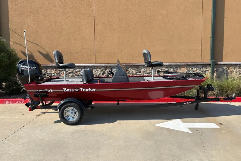 The Image of 2026 Tracker Bass Tracker Classic XL boat, red, on trailer, parked outdoors. - 0