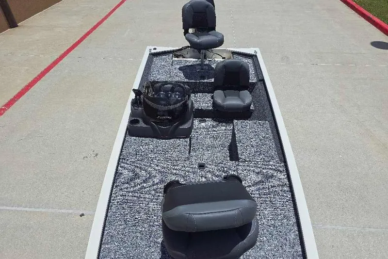 Slide: The Image of 2026 Tracker Pro 170 boat interior with seating and fishing equipment on a concrete surface. - 12