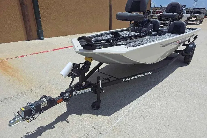 Slide: The Image of 2026 Tracker Pro 170 boat on trailer, parked outdoors, showcasing sleek design and seating. - 2