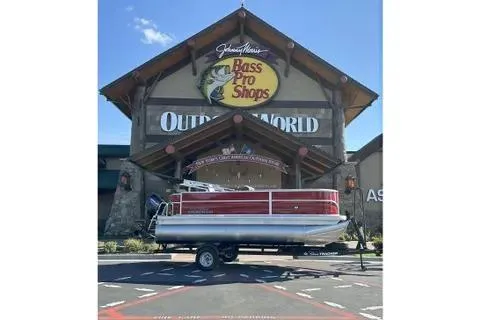 The Image of 2026 Sun Tracker Party Barge 18 DLX pontoon boat outside Bass Pro Shops. - 0