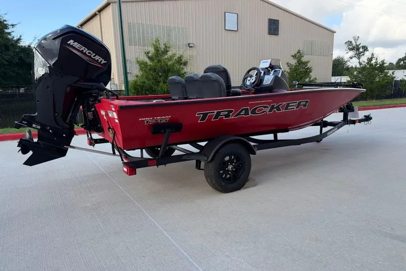 Slide: The Image of 2026 Tracker Pro Team 175 Crappie Edition boat on trailer, red exterior, parked outdoors. - 2