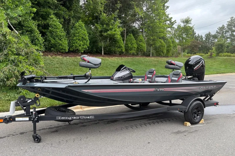 Slide: The Image of 2026 Ranger RT178 boat on trailer, parked on road with lush greenery background. - 1