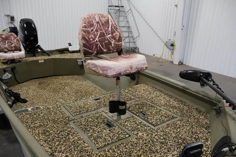 Slide: The Image of 2014 Lowe Roughneck 1756 boat interior with camo seats and fishing equipment. - 15