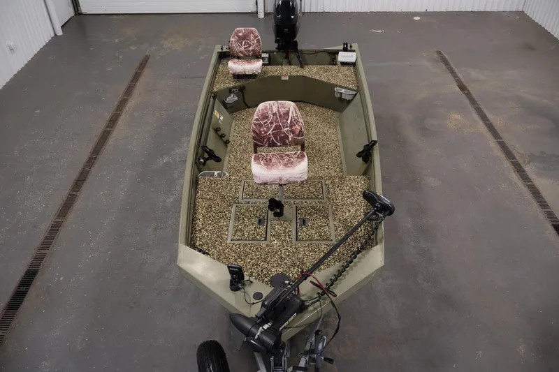 Slide: The Image of 2014 Lowe Roughneck 1756 boat with camouflage seats in a garage setting. - 9