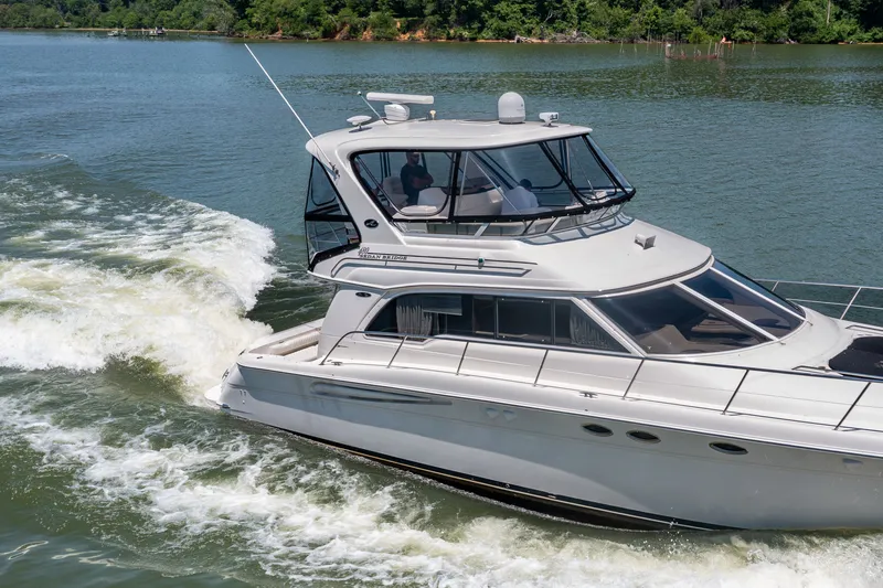 Slide: The Image of 2003 Sea Ray 480 Sedan Bridge cruising on a serene lake. - 27