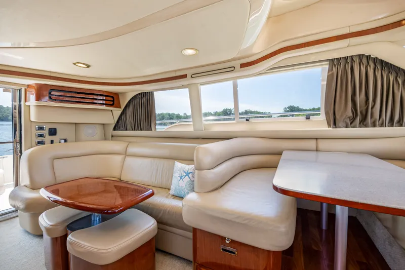Slide: The Image of Interior of 2003 Sea Ray 480 Sedan Bridge with leather sofa and wooden table. - 37