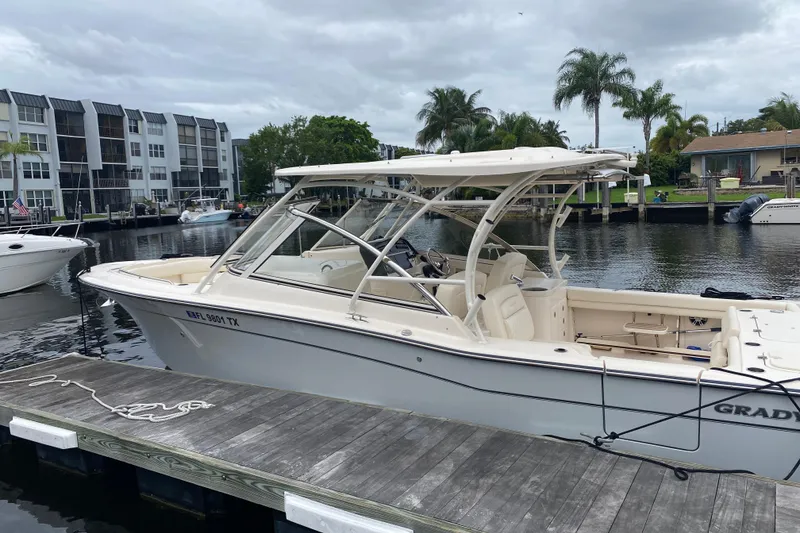 Slide: The Image of 2025 Grady-White Freedom 307 boat docked by waterfront homes and palm trees. - 1