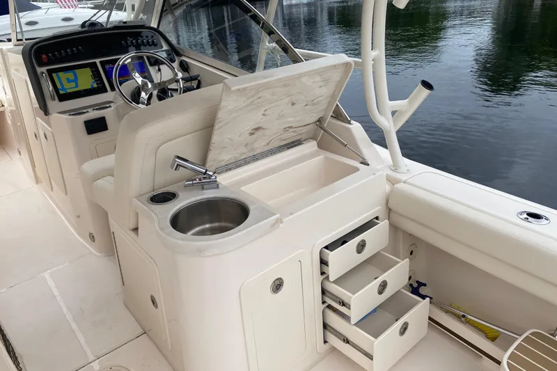 Slide: The Image of 2025 Grady-White Freedom 307 boat interior with helm, sink, and storage drawers. - 18