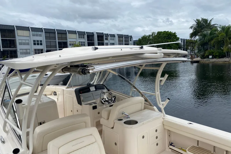 Slide: The Image of 2025 Grady-White Freedom 307 boat docked near waterfront buildings and palm trees. - 19