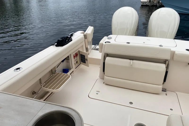 Slide: The Image of 2025 Grady-White Freedom 307 boat interior with seating and storage, docked by the water. - 20