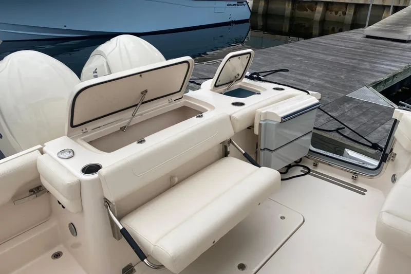 Slide: The Image of 2025 Grady-White Freedom 307 boat interior with seating and storage compartments at dock. - 22