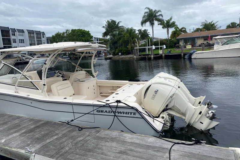The Image of 2025 Grady-White Freedom 307 boat docked by a waterfront, featuring twin Yamaha engines. - 23