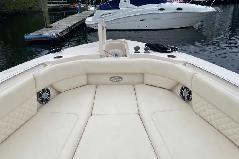 Slide: The Image of 2025 Grady-White Freedom 307 boat interior with plush seating and speakers at a dock. - 3