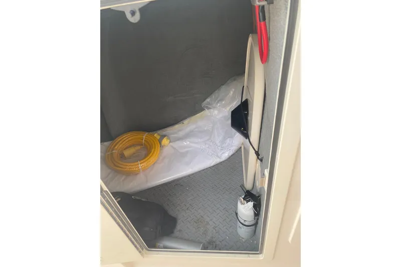 Slide: The Image of Interior storage compartment of 2025 Grady-White Freedom 307 boat with coiled yellow hose. - 6