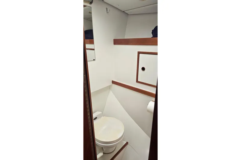 Slide: The Image of Bathroom interior of a 1995 Contest 46/48 yacht, featuring a toilet and wooden accents. - 45
