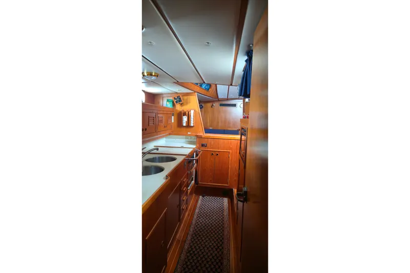 Slide: The Image of Interior of a 1995 Contest 46/48 yacht, featuring a wooden galley with modern amenities. - 29