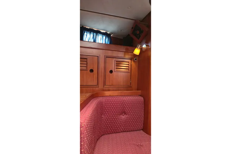 Slide: The Image of Interior of a 1995 Contest 46/48 yacht with wooden cabinets and red upholstered seating. - 35