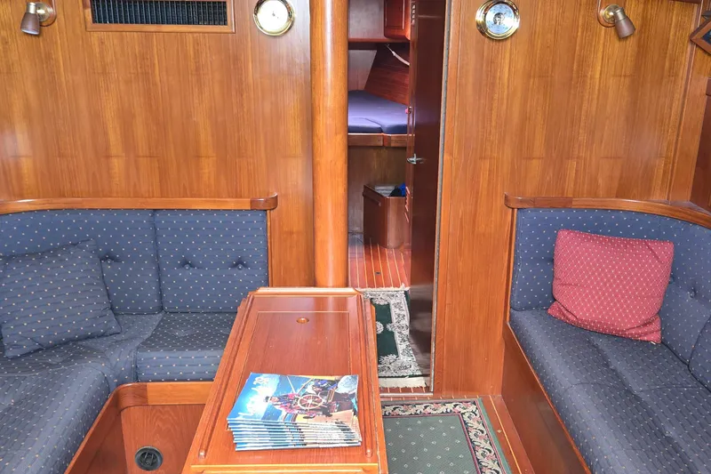 Slide: The Image of Cozy 1995 Contest 46/48 yacht interior with wooden paneling and cushioned seating. - 38