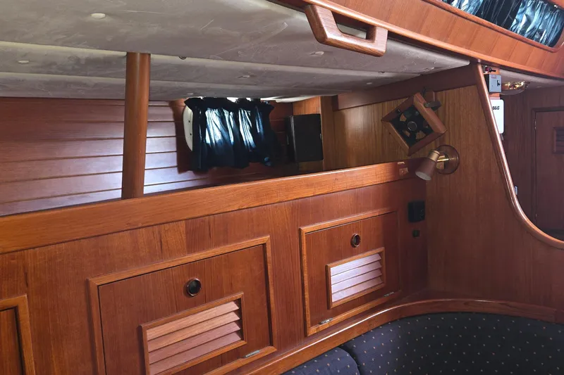 Slide: The Image of Interior of a 1995 Contest 46/48 yacht with polished wood paneling and cozy seating. - 42
