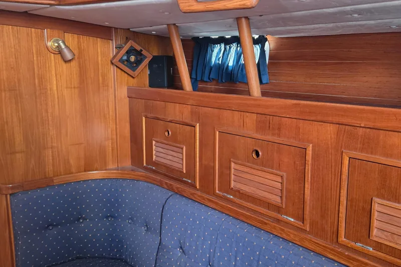 Slide: The Image of Interior of a 1995 Contest 46/48 yacht with wooden paneling and blue upholstery. - 36