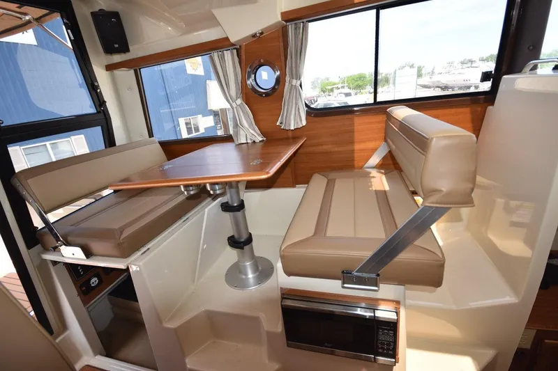 Slide: The Image of 2024 Ranger Tugs R-25 interior dining area with table and cushioned seating. - 17