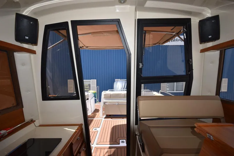 Slide: The Image of Interior view of 2024 Ranger Tugs R-25, showcasing seating and deck access. - 24