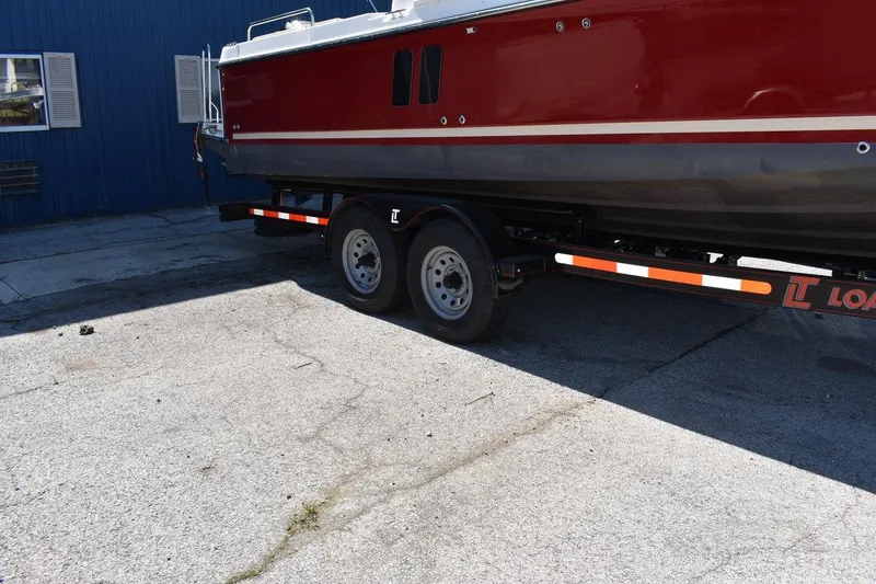 Slide: The Image of 2024 Ranger Tugs R-25 boat on trailer, parked on concrete surface. - 31