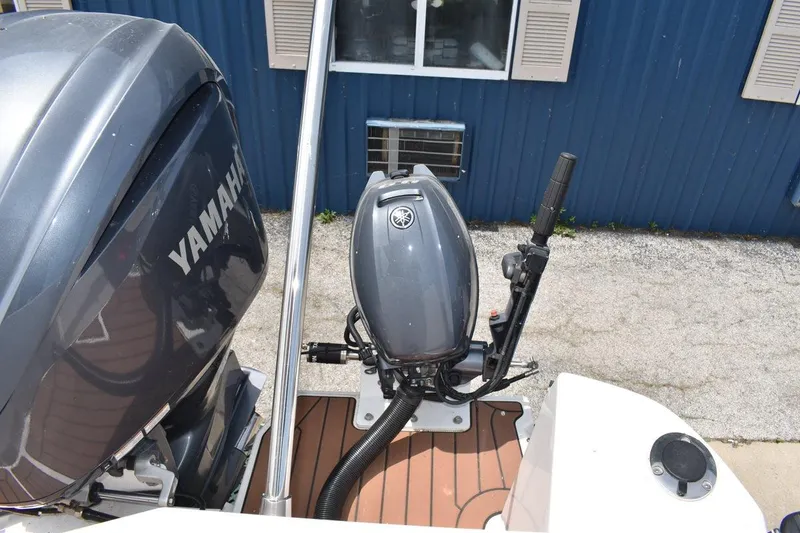 Slide: The Image of 2024 Ranger Tugs R-25 with Yamaha outboard motor, docked near blue building. - 7
