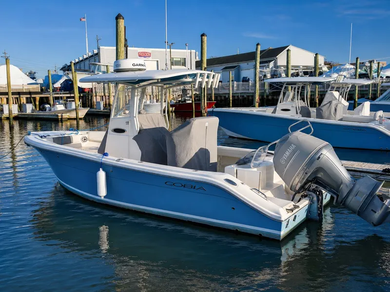Slide: The Image of 2020 Cobia 240 Center Console boat docked at marina. - 1