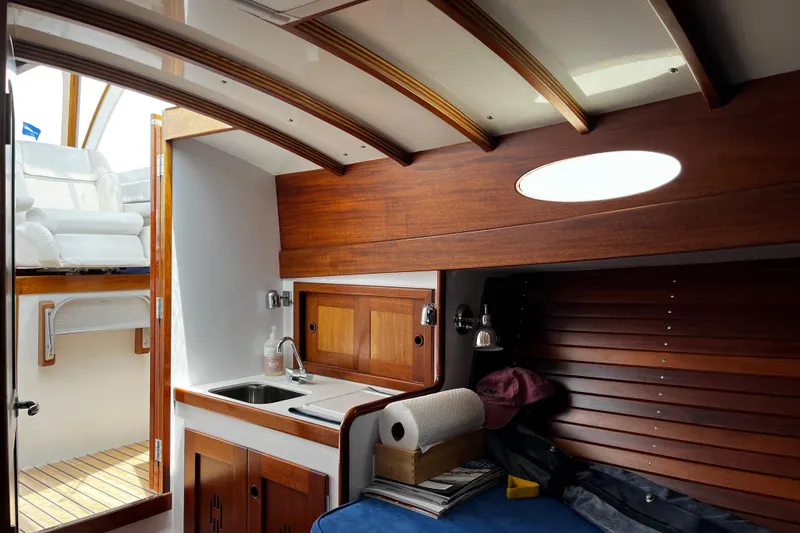 Slide: The Image of Interior of 2001 Lyman-Morse Monhegan 30 yacht with wooden cabinetry and compact kitchenette. - 10