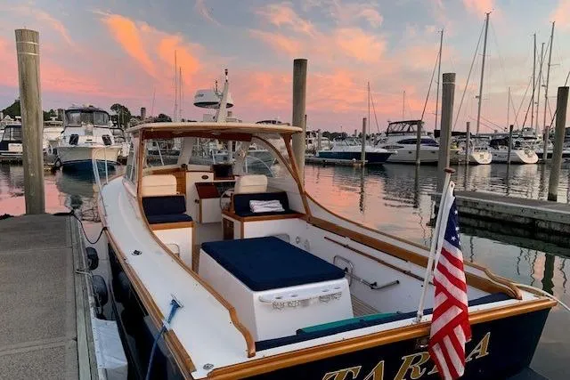 Slide: The Image of Lyman-Morse Monhegan 30 boat docked at sunset, 2001 model, with American flag. - 2