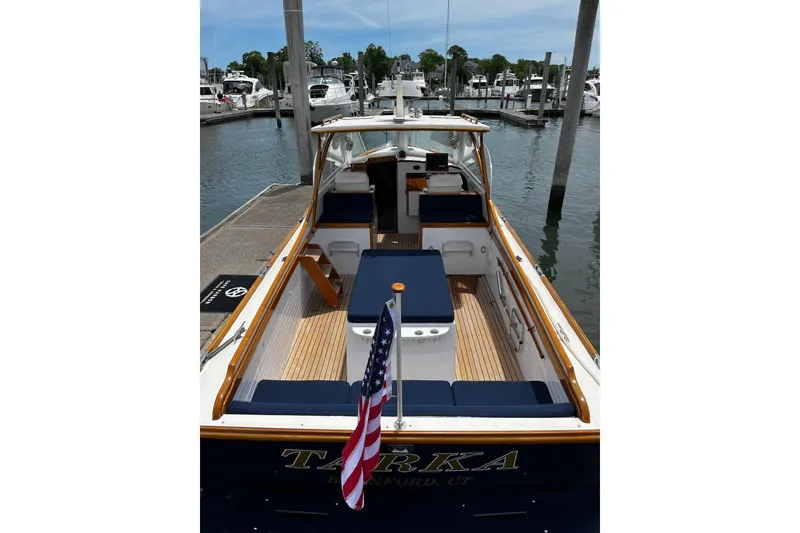 Slide: The Image of 2003 Lyman-Morse Monhegan 30 boat docked, featuring blue seating and American flag. - 3